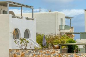 a white house with an umbrella and a building at Martha's filoxenia in Drios