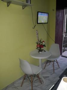 two chairs and a table with a tv on a wall at Loft Amazônia in Belém