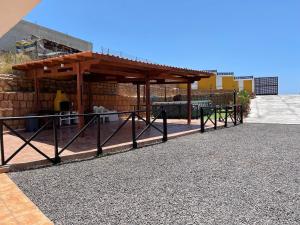 um gazebo com uma cerca em frente a um edifício em Casa Cueva Los Mansos em Santa Cruz de Tenerife