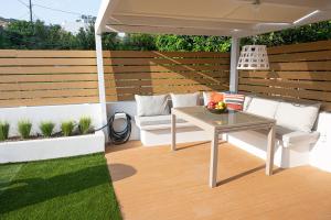 a patio with a table and a couch under an umbrella at Orsalia villa wellness in Poros