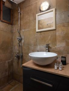 uma casa de banho com um lavatório branco e um chuveiro em Menexes Suites Monemvasia em Monemvasia