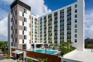 an exterior view of a building with a swimming pool at Aloft Miami Aventura in Aventura