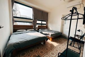 - une chambre avec 2 lits dans l'établissement 鴉埠客棧x南華大旅社, 