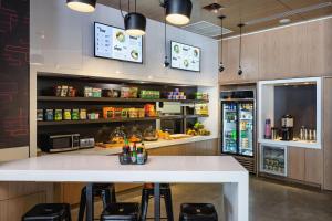 a kitchen with a large white counter and stools at Aloft Miami Aventura in Aventura