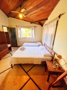 a bedroom with a large bed and a wooden ceiling at Casa na linda praia de Jericoacoara in Jericoacoara