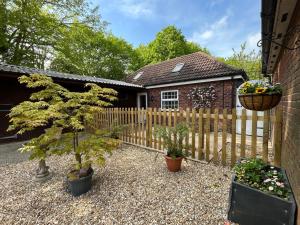 a house with a wooden fence and some plants at Stable End Cottage in Spilsby