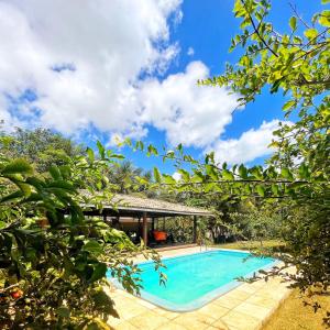 - une piscine avec un kiosque et un ciel bleu dans l'établissement Casa na linda praia de Jericoacoara, à Jericoacoara