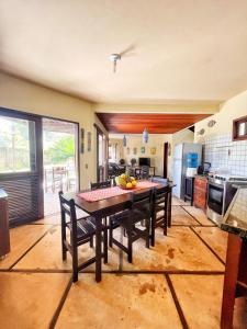 a kitchen with a wooden table with chairs and a dining room at Casa na linda praia de Jericoacoara in Jericoacoara