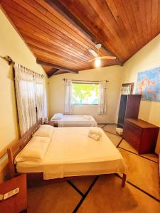 Cette grande chambre comprend deux lits et une fenêtre. dans l'établissement Casa na linda praia de Jericoacoara, à Jericoacoara