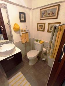 a bathroom with a white toilet and a sink at Estancia Sonrisas de Ángeles in Constanza