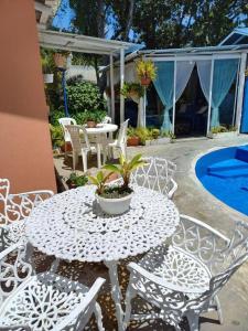 a white table and chairs and a pool at Estancia Sonrisas de Ángeles in Constanza