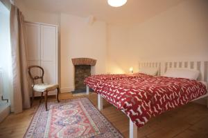 1 dormitorio con cama roja y chimenea en Pentreath, Crackington Haven, en Crackington Haven