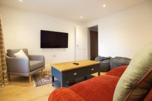 sala de estar con sofá, mesa y TV en Pentreath, Crackington Haven, en Crackington Haven