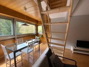 Habitación con escalera, mesa y sillas en Apartamento Duplex en La Molina, en Alp