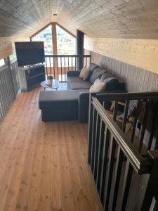 a living room with a couch and a flat screen tv at Ny hytte med sjøen. Fantastisk utsikt. Lofoten in Svensgam