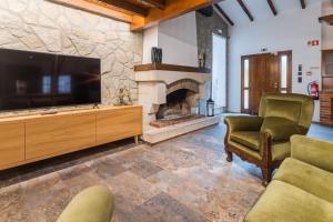 a living room with a large television and a fireplace at Quinta Devesa do Monte in Amares
