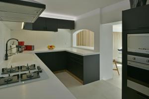 uma cozinha com armários pretos e um balcão branco em The Red Cloud 3 em Saint Barthelemy