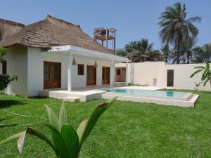 a house with a swimming pool in the yard at la maison de la fontaine in Cap Skirring