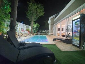 a swimming pool in a backyard at night at וילה מונטאנו עם בריכה מחוממת וג'קוזי במרכז העיר - Villa Montano with a heated pool and jacuzzi in the city center in Rishon LeẔiyyon