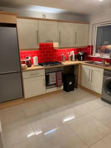 uma cozinha com armários brancos e uma parede de tijolos vermelhos em Inse House Laytown em Laytown