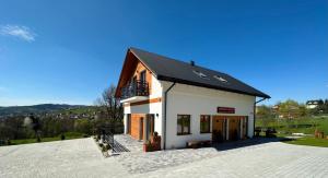 a small white building with a black roof at Apartamenty na Wyrszczku Apartament nr 3 in Istebna