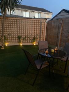 een patio met een tafel en stoelen in een tuin bij Inse House Laytown in Laytown