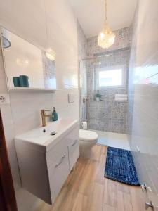 a bathroom with a white sink and a toilet at Farfalle in Petacciato