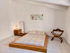 a bedroom with a bed and a chair and a mirror at Farfalle in Petacciato