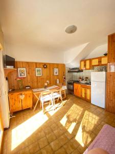 a kitchen with a table and a white refrigerator at Un posto al sole in Fregene