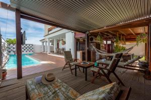 a patio with a hammock and a swimming pool at Acogedora casita en la Subbética, centro de Andalucía, Granada y Córdoba in Zambra