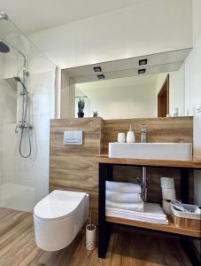 a bathroom with a sink and a toilet and a mirror at Apartamenty na Wyrszczku Apartament nr 3 in Istebna