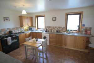 a kitchen with wooden cabinets and a table and a stove at Campston in Toab