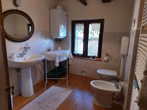 a bathroom with two sinks and a toilet and a mirror at VILLINO AMELIATTE in Cison di Valmarino