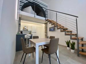 uma sala de jantar com uma mesa e uma escada em Loft Nineteen Apartment em La Spezia