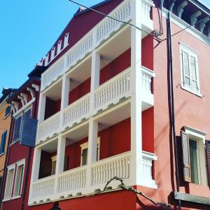 czerwono-biały budynek z białym balkonem w obiekcie Hotel Danieli La Castellana lago di Garda w Brenzone sul Garda