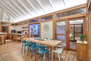 a dining room with a wooden table and blue chairs at Aloha 10 I 4Bed Villa with Stunning Sea View Pool in Ponta Mamoli