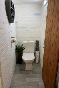 a bathroom with a toilet and a toilet paper dispenser at Spacious three bedroom house with off road parking in Birmingham