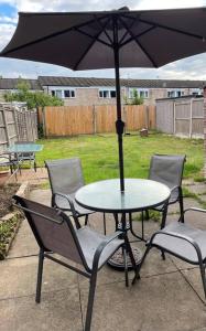 a table and chairs with an umbrella on a patio at Spacious three bedroom house with off road parking in Birmingham