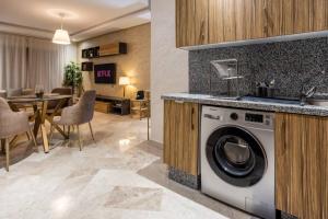 a kitchen and living room with a washing machine at Modern Charm at Le Joyau du Parc in Mohammedia