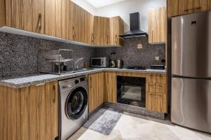 a kitchen with a washer and a dishwasher at Modern Charm at Le Joyau du Parc in Mohammedia
