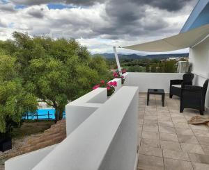 uma varanda com uma cerca branca e flores sobre ela em Agriturismo Palas De Serra Country Resort em Onifai