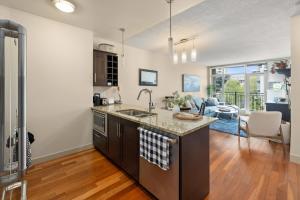 een open keuken met een wastafel en een woonkamer bij Aria Escape by Iris Properties! in Victoria