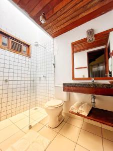 a bathroom with a shower and a toilet and a mirror at Casa na linda praia de Jericoacoara in Jericoacoara