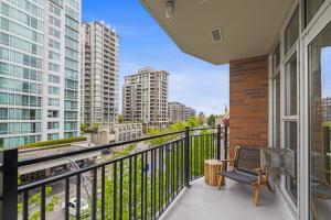 a balcony with a bench and some tall buildings at Aria Escape by Iris Properties! in Victoria