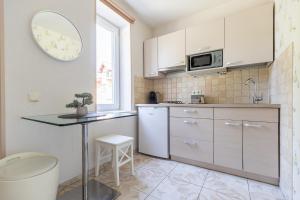 a kitchen with white cabinets and a table and a window at Mare Apartments in Palanga