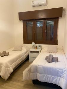 duas camas sentadas uma ao lado da outra num quarto em Apartamento Completo en el centro de Durazno em Durazno