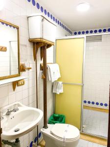 a bathroom with a sink and a toilet and a shower at Hotel Casa Yaripa in Manizales