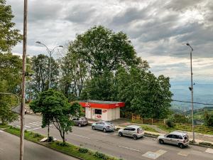 a parking lot with cars parked in front of a gas station at Hotel Casa Yaripa in Manizales