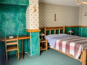 a bedroom with a bed and a table and a chair at Hotel Casa Yaripa in Manizales