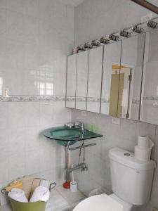 La salle de bains blanche est pourvue d'un lavabo et de toilettes. dans l'établissement The Views Will Take Your Breath Away - Romantic Villa on the Beach, à Arecibo